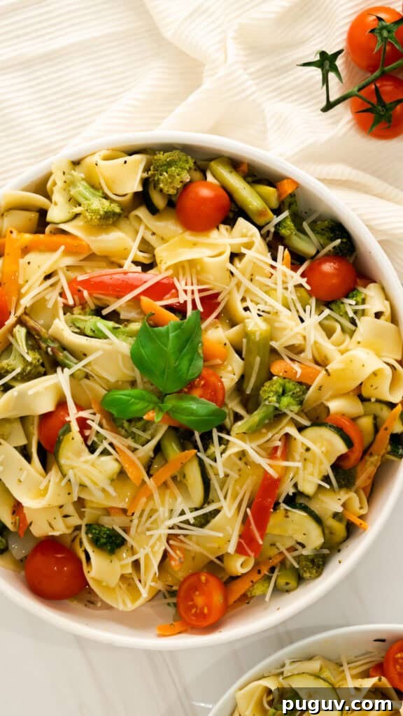 Instant Pot Pasta Primavera Recipe: Quick Veggie One-Pot Meal 2 A large bowl of Instant Pot Pasta Primavera with fresh basil, parmesan, and halved cherry tomatoes.