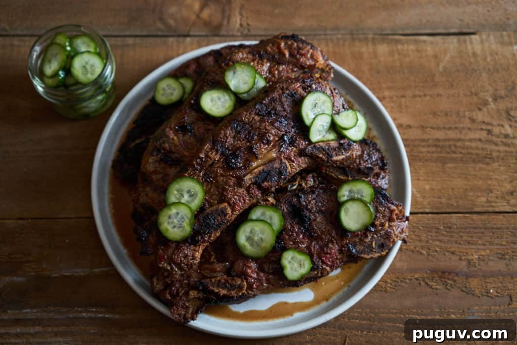 Grilled beef short ribs on a white plate topped with quick pickles.