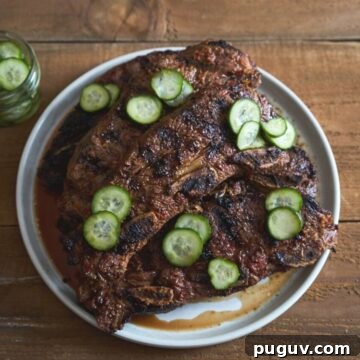 Grilled beef short ribs on a white plate topped with quick pickles.