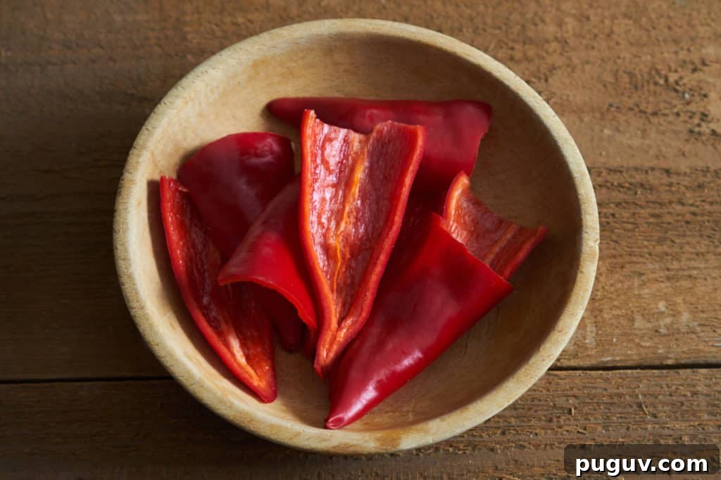 Red Fresno chiles, sliced in half and seeds removed, in a wooden bowl.