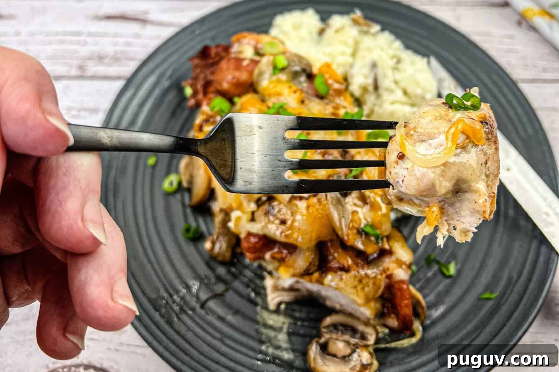 17 Low-Carb Meals That Keep You Full, Energized, and Ready 12 Close-up of a hand holding a fork with a bite of copycat Alice spring chicken.