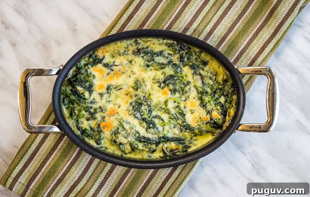 17 Low-Carb Meals That Keep You Full, Energized, and Ready 9 Steakhouse Creamed Spinach in a black dish on a cloth.