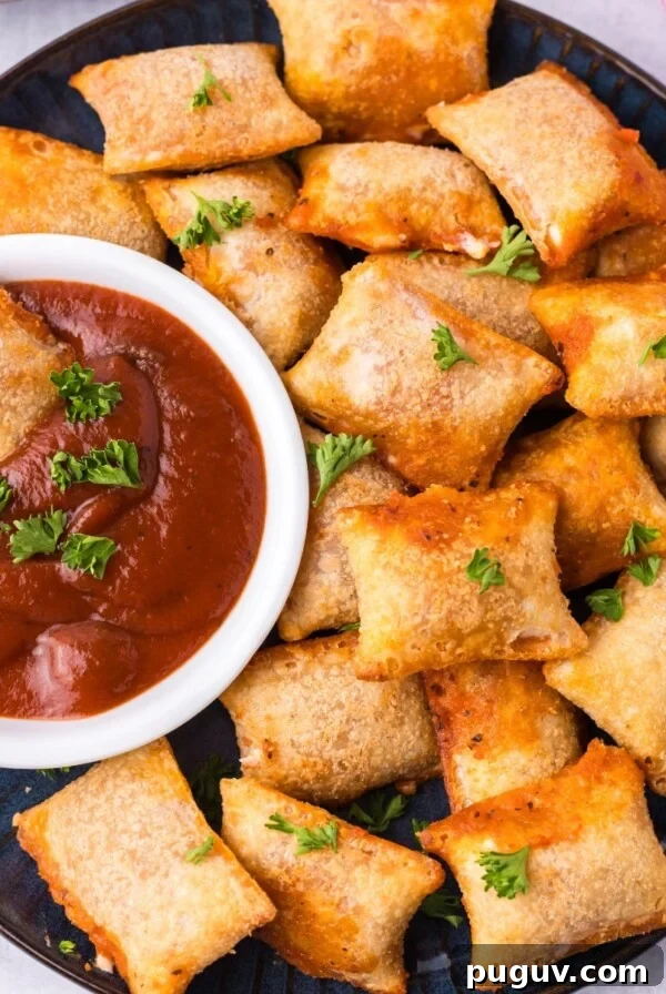 Crispy-On-The-Outside, Soft-On-The-Inside Air Fryer Pretzels 13 Air fryer pizza rolls on a plate with one dipped in tomato sauce.