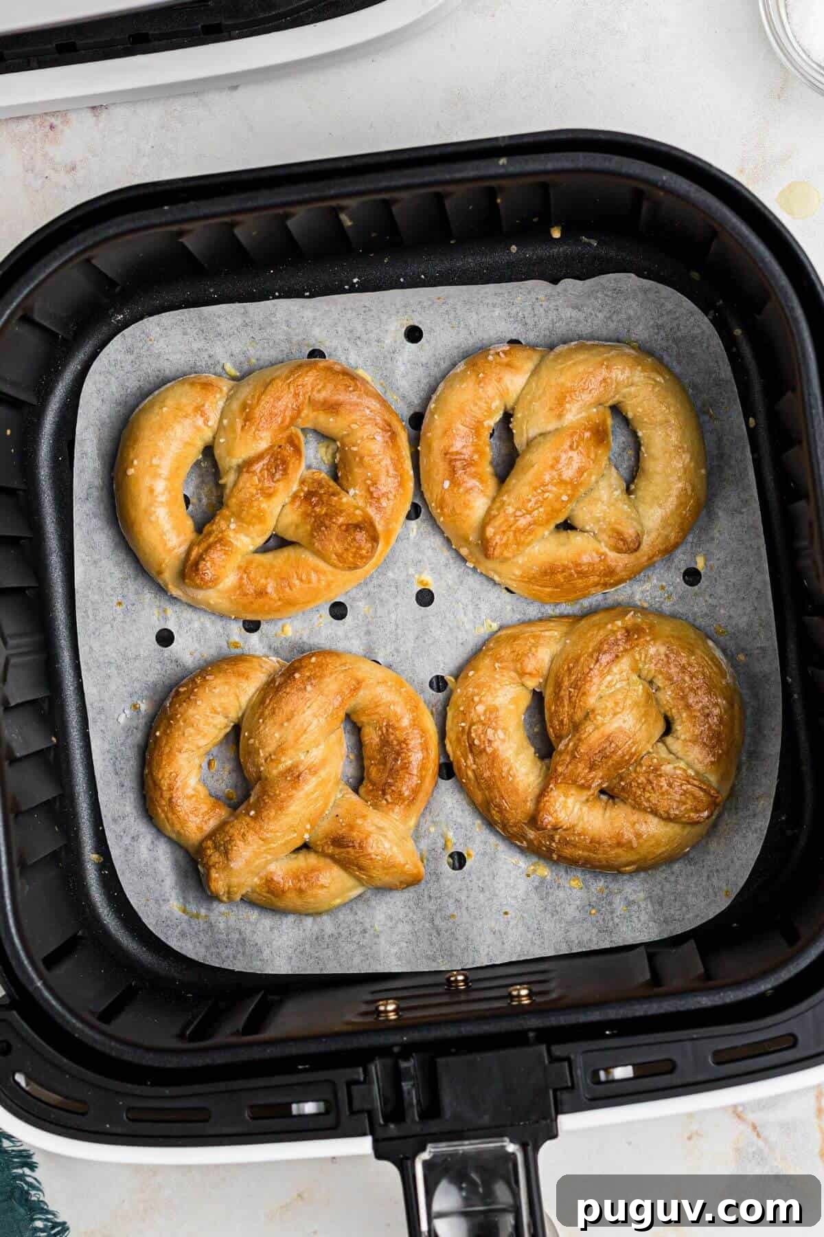 Crispy-On-The-Outside, Soft-On-The-Inside Air Fryer Pretzels 9 Golden brown soft pretzels in the air fryer basket after being cooked.