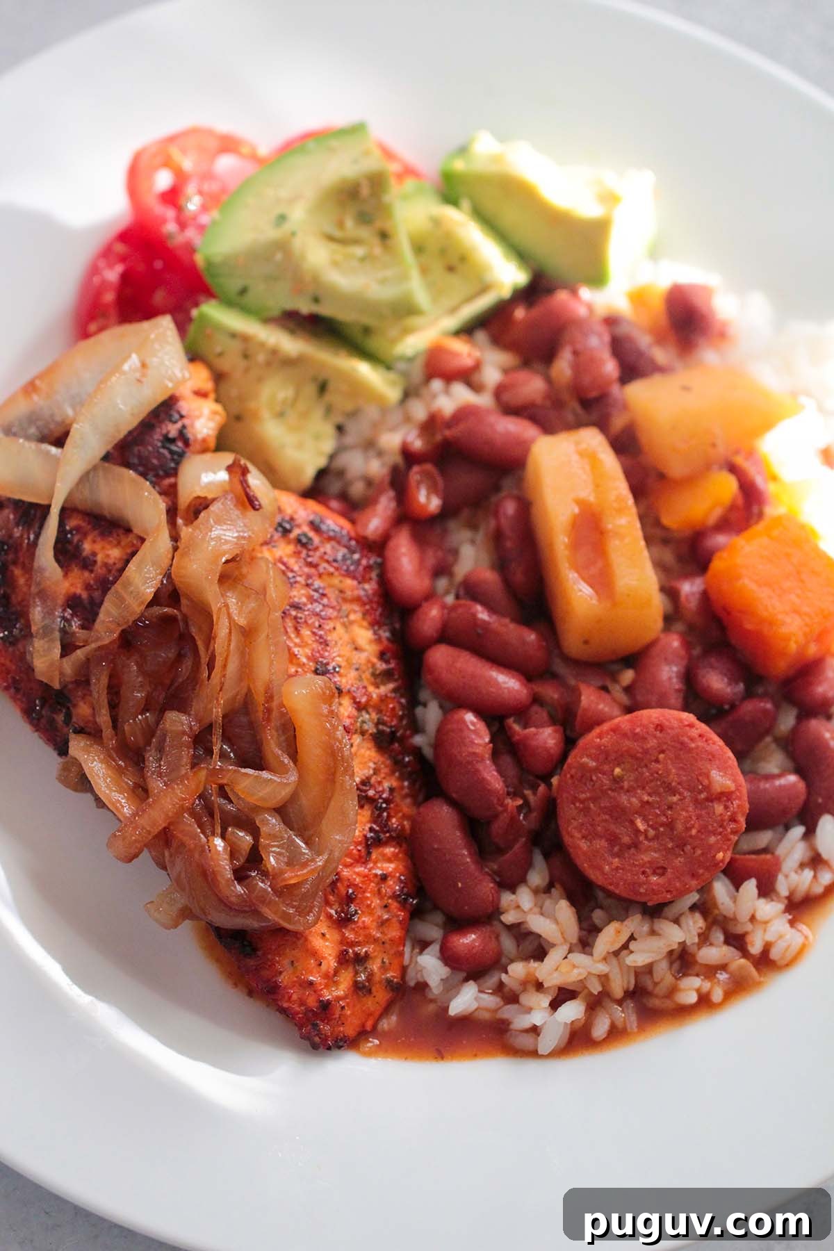 rice, beans, chicken, and avocado salad on a plate.