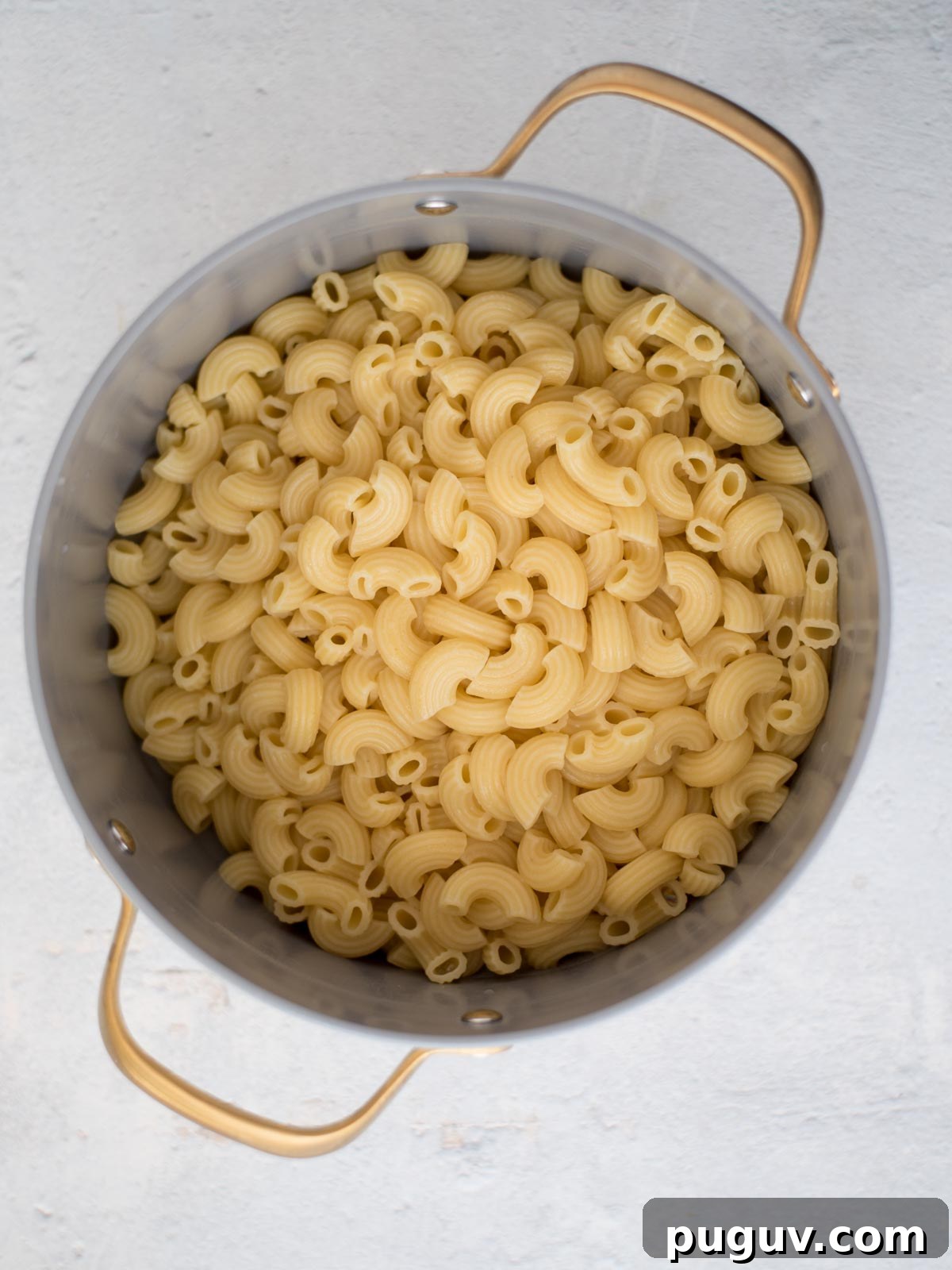 Creamy Baked Macaroni and Cheese Casserole 7 Cooked pasta in a saucepan.