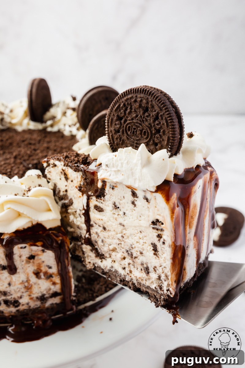 Decadent Oreo Ice Cream Cake Recipe for Parties and Birthdays 5 A slice of Oreo Ice cream cake, being lifted away from the full cake with a cake server.