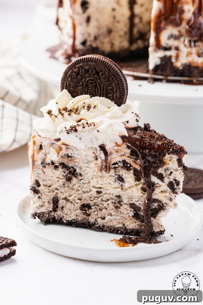 Decadent Oreo Ice Cream Cake Recipe for Parties and Birthdays 6 a slice of scratch made oreo ice cream cake, viewed from the side, on a small white plate.