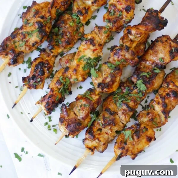 Crispy Homemade Chicken Nuggets Recipe for Family Meals 8 Overhead photo of chicken kebabs on bamboo skewers on white plate.