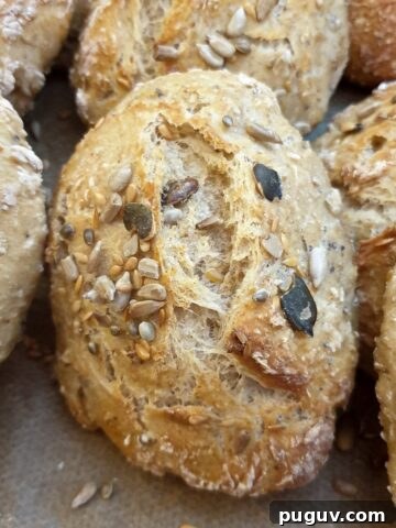 Close up of a baked seeded bread roll.