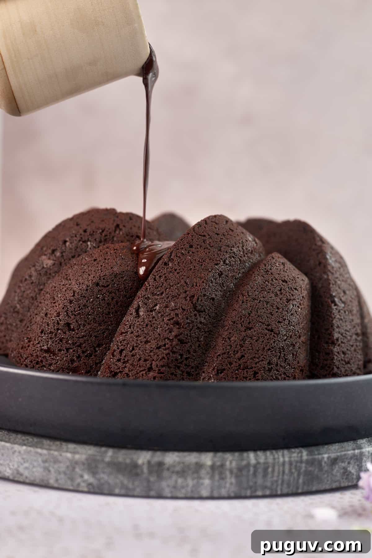 bundt cake being topped with chocolate icing