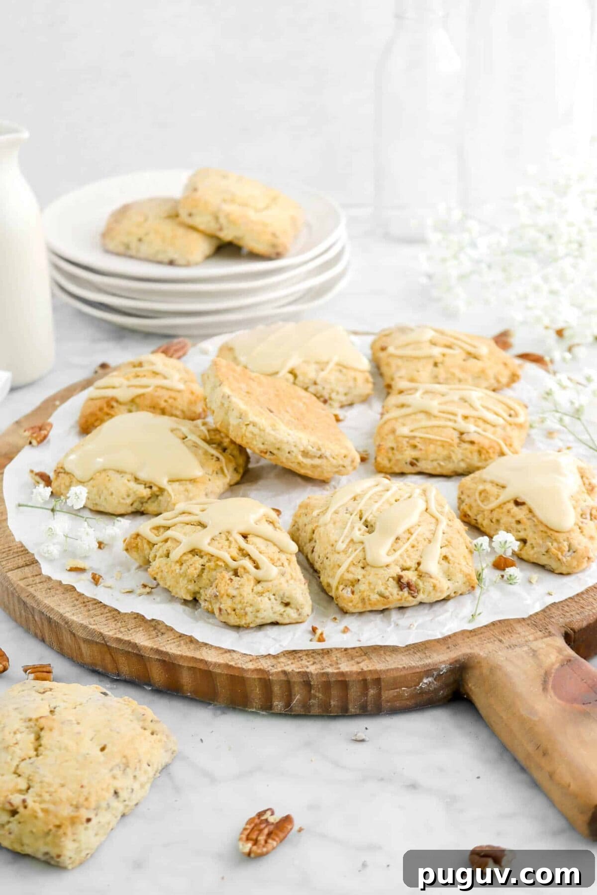 Maple Pecan Scones with Sweet Maple Glaze 3 side shot of maple pecan scones on wood serving board with flowers and stacked plates