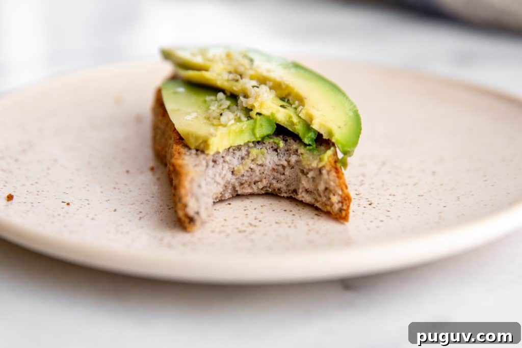 No-Yeast Vegan Almond Bread (Grain-Free, Paleo Recipe) 9 A slice of bread topped with avocado, with a bite taken out.