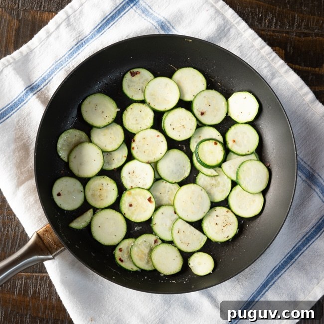 10-Minute Sautéed Zucchini with Fresh Herbs and Lemon Zest 3 Zucchini slices in a skillet before sautéeing.
