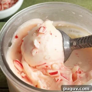 Ninja Creami peppermint ice cream being scooped out of the clear pint container.