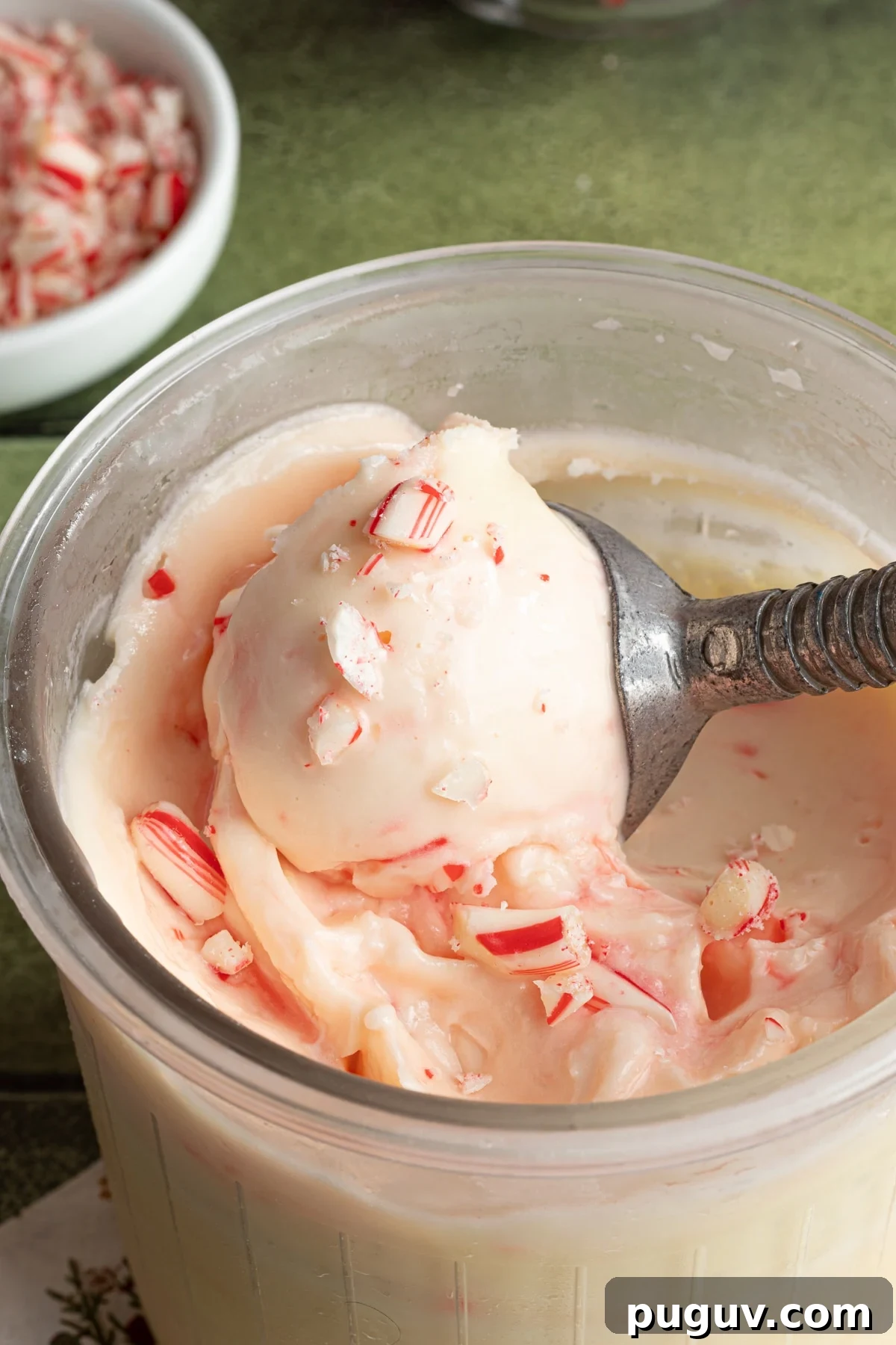 Ninja Creami peppermint ice cream being scooped out of the clear pint container.