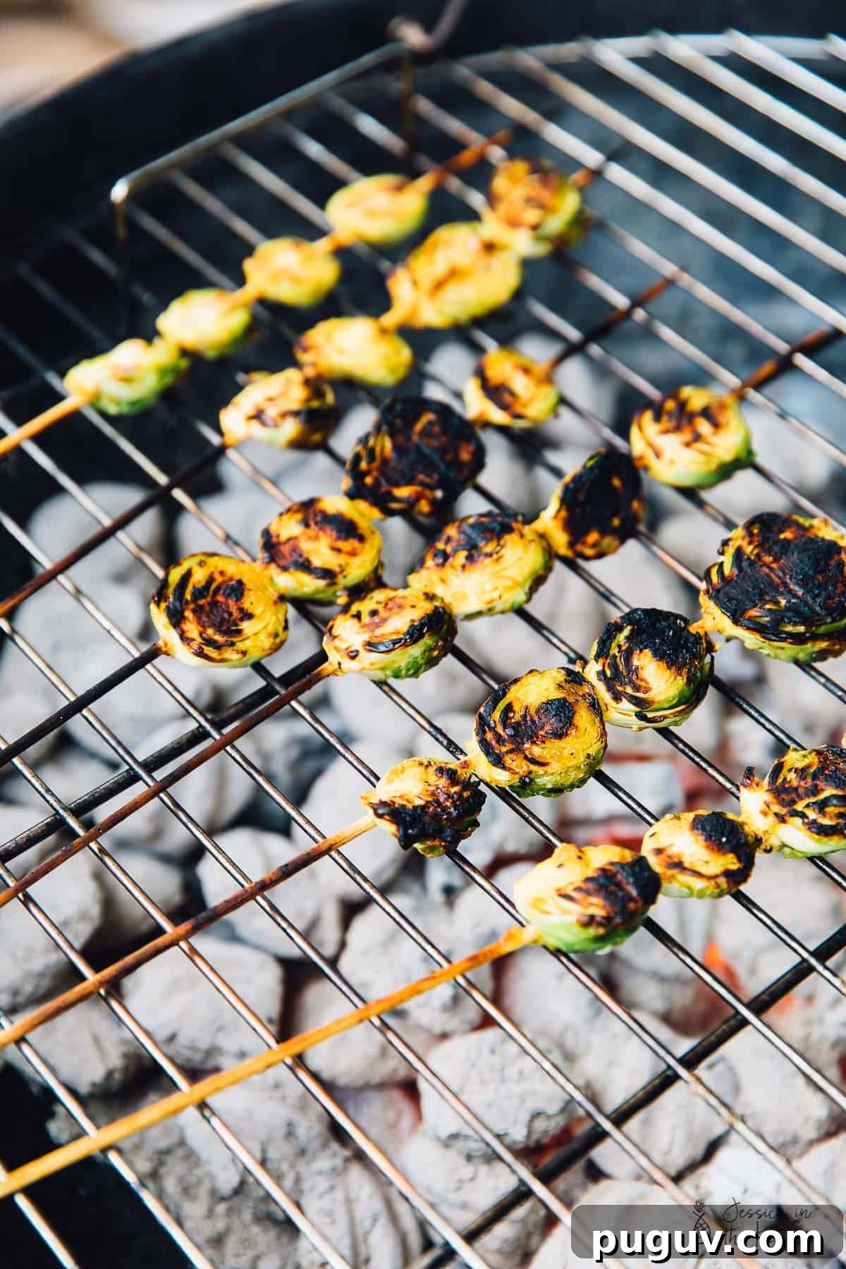 Grilled Brussels Sprouts with Maple Mustard Glaze 5 Skewers of maple mustard brussels sprouts on a bbq grill.
