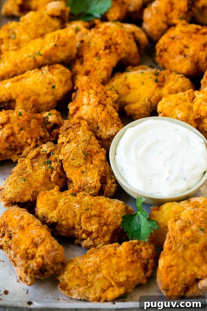 Wings with parsley and ranch Fried chicken wings with parsley and a side of ranch dip.