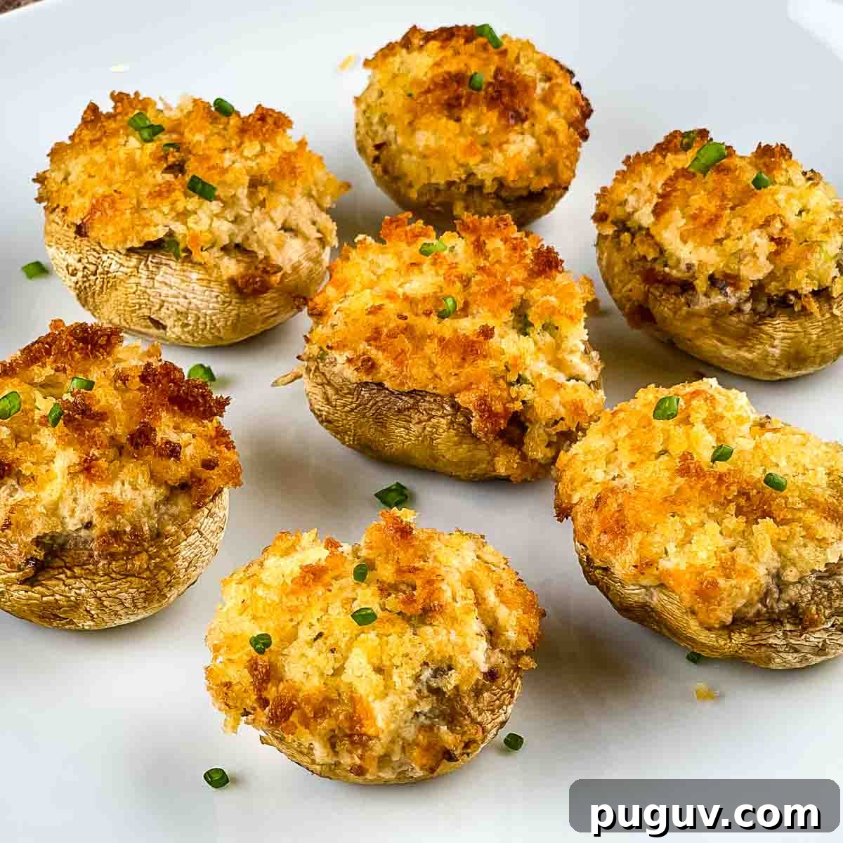 Crispy air fryer stuffed mushrooms on a white serving platter.