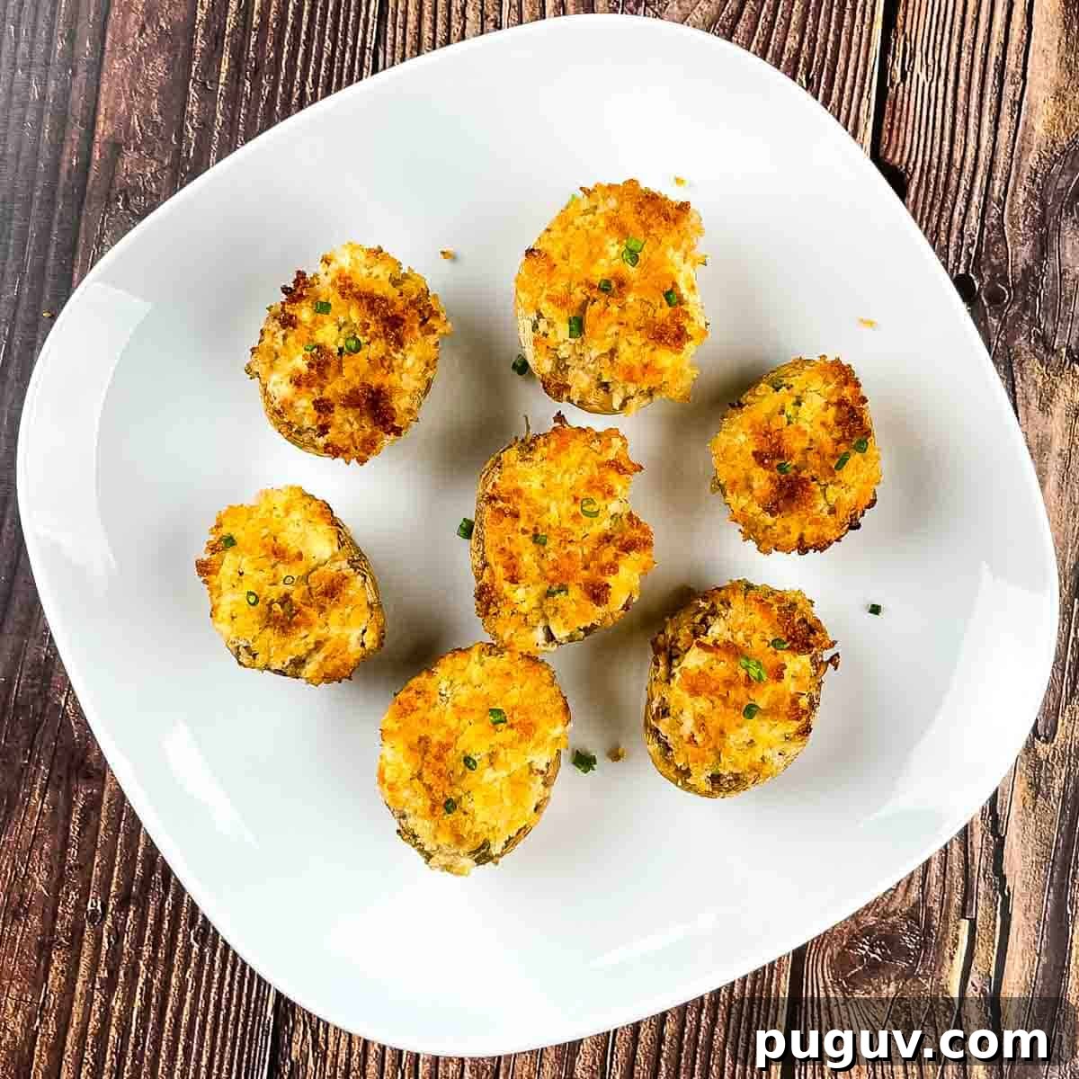 The air fryer sturffed mushrooms on a white serving plate.