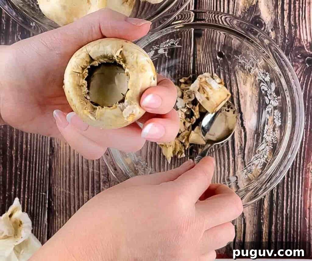 A hand removing the stem from the mushroom.
