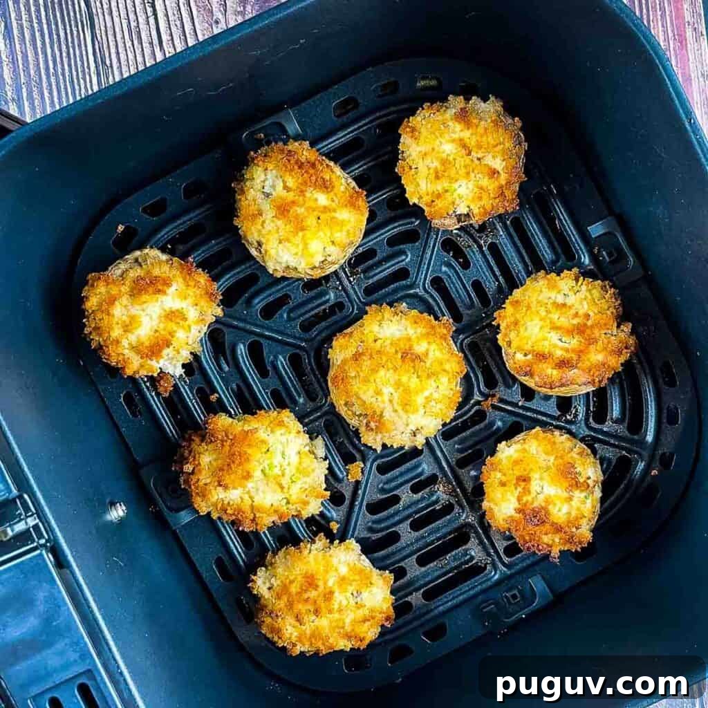 The cooked stuffed mushrooms in the air fryer basket.