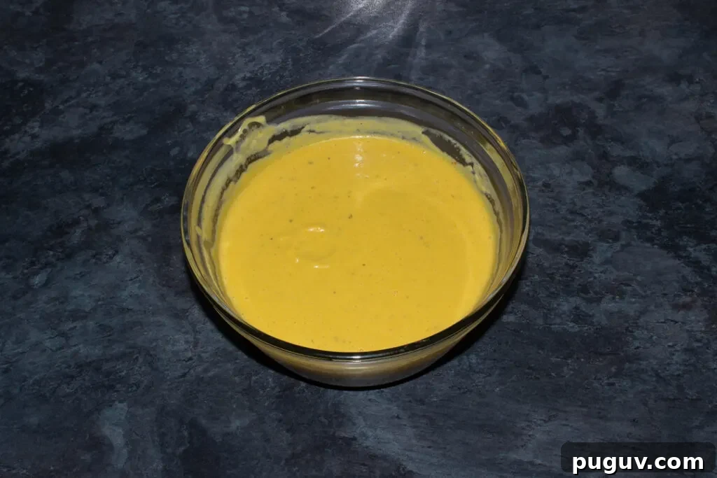 Blended spicy roast butternut squash in a glass bowl on a kitchen worktop.