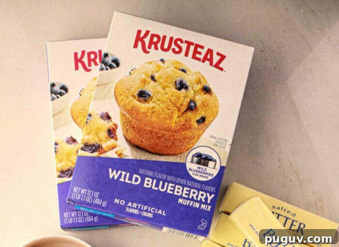 Upgrade Your Blueberry Muffin Mix: Simple Tips for Moist, Flavorful Muffins 3 Box of Krusteaz Blueberry muffin mix on a counter next to butter packets and another muffin mix box, ready to help you improve your recipe.