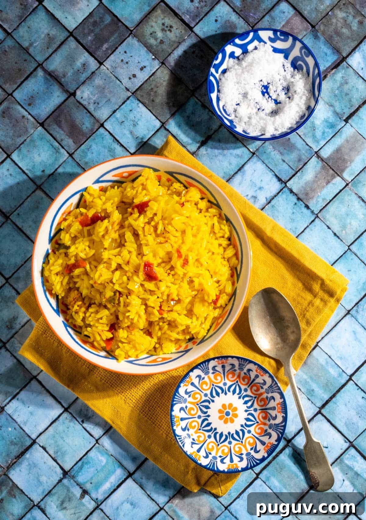 Authentic Spanish Arroz Amarillo (Saffron Yellow Rice) 2 Arroz Amarillo in a bowl on top of a yellow napkin.