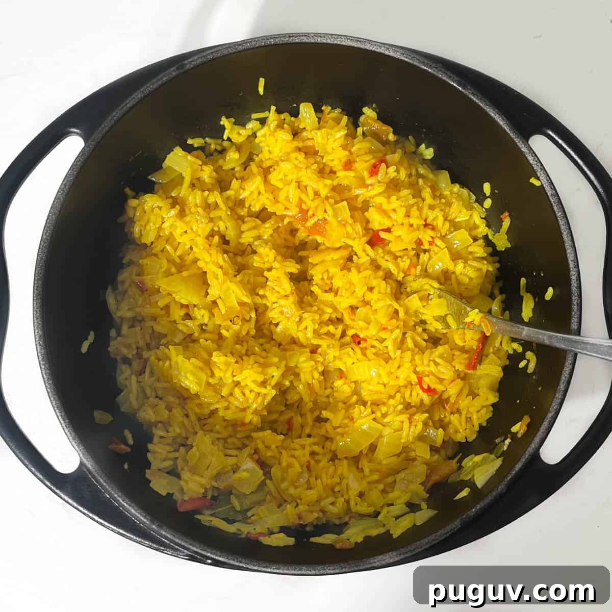 Authentic Spanish Arroz Amarillo (Saffron Yellow Rice) 6 Fluffing up the Arroz Amarillo with a fork.