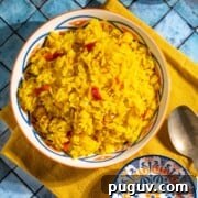 Authentic Spanish Arroz Amarillo (Saffron Yellow Rice) 7 Arroz Amarillo in a bowl on top of a yellow napkin.