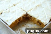 Pumpkin Chocolate Chip Cookies Made from Cake Mix 10 Cut Pumpkin Chocolate Chip Bars with Cream Cheese Frosting in a large cookie sheet with a piece missing from a corner.