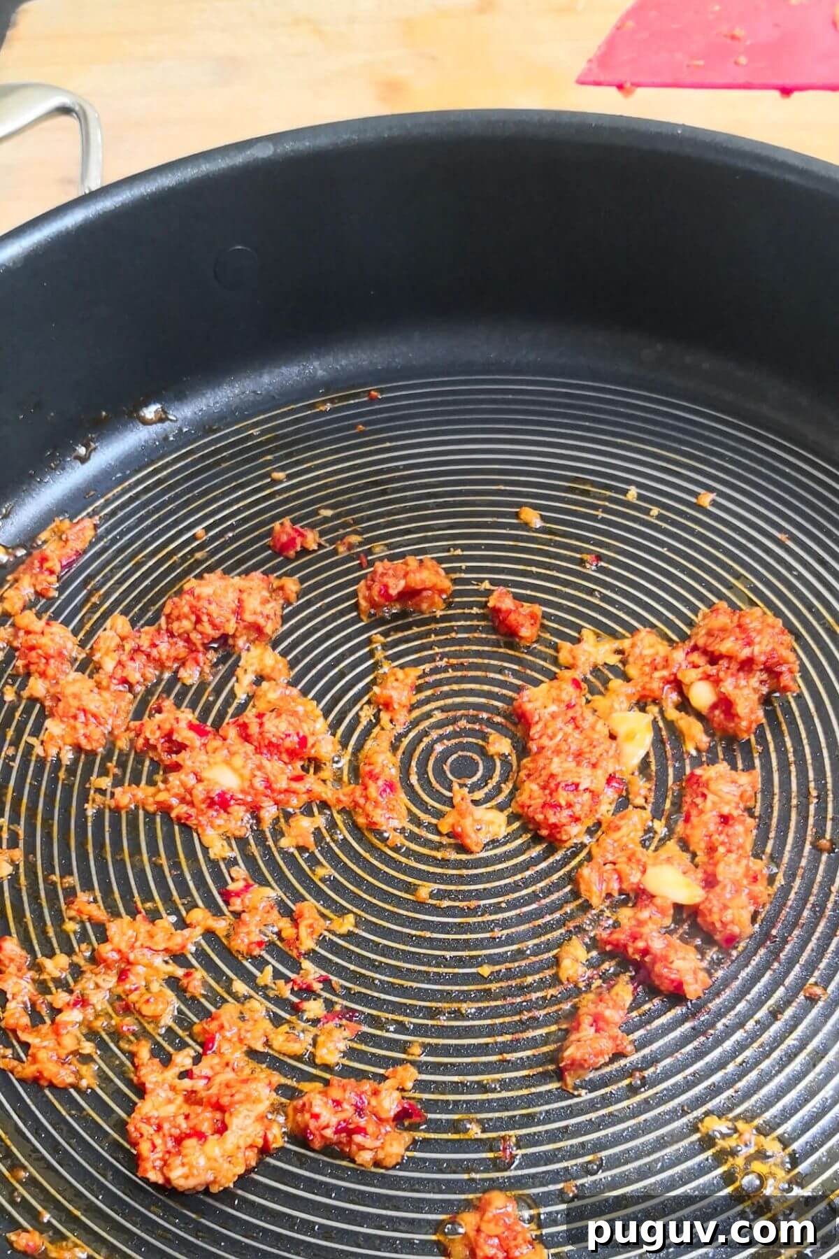 Spicy ’Nduja Pasta with Creamy Burrata Cheese 4 Nduja frying in a large black pan.