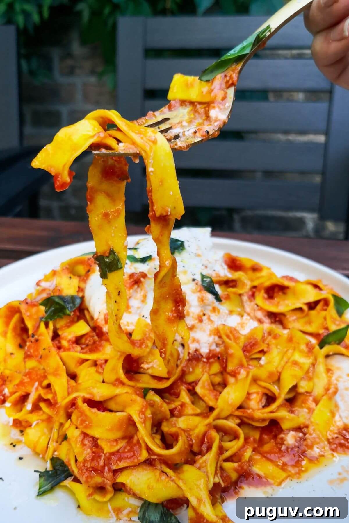 Spicy ’Nduja Pasta with Creamy Burrata Cheese 10 Nduja pasta being pulled up by a fork from a large whie plate of pasta.