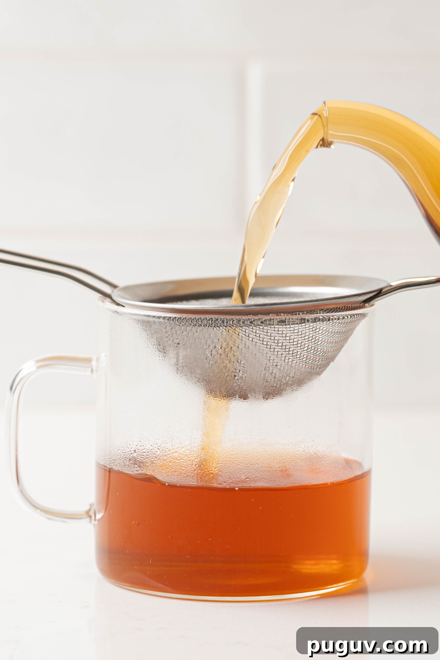 Cinnamon tea straining into a mug.