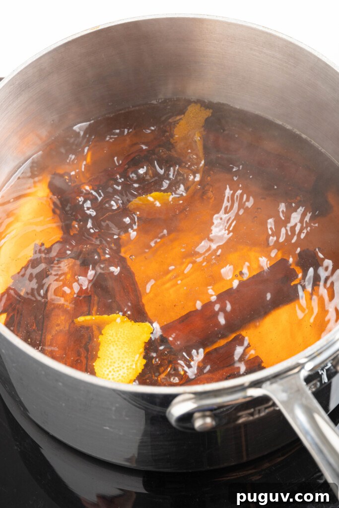 Cinnamon sticks boiling with water and orange peel.