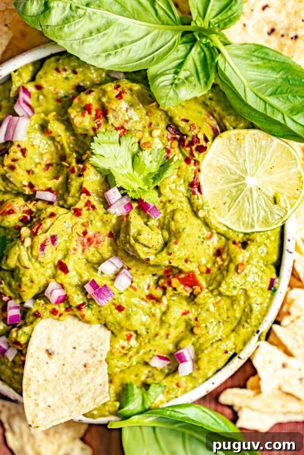 Mango Habanero Salsa Recipe — Sweet Heat with Fresh Mango 11 guacamole in a bowl surrounded by tortilla chips and garnished with fresh basil.