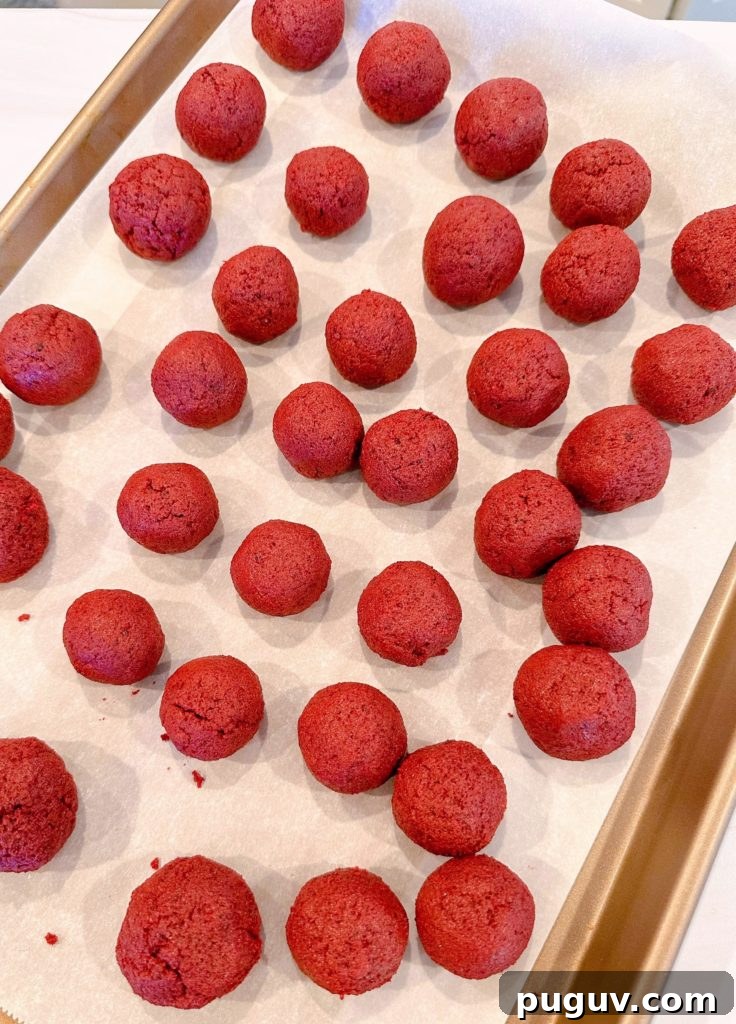 Red Velvet Cake Pops: Bite-Sized Dessert Recipe Guide 6 Cake balls are rolled and placed on a parchment-lined baking sheet.