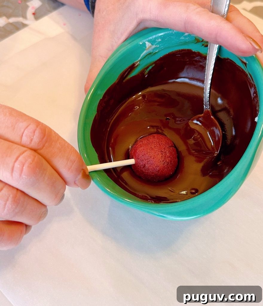 Red Velvet Cake Pops: Bite-Sized Dessert Recipe Guide 7 Dipping cake pops into melted chocolate.