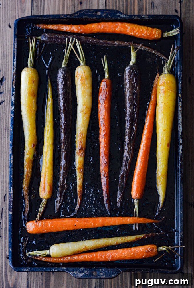 A pan of cooked rainbow carrots on a cookie sheet.