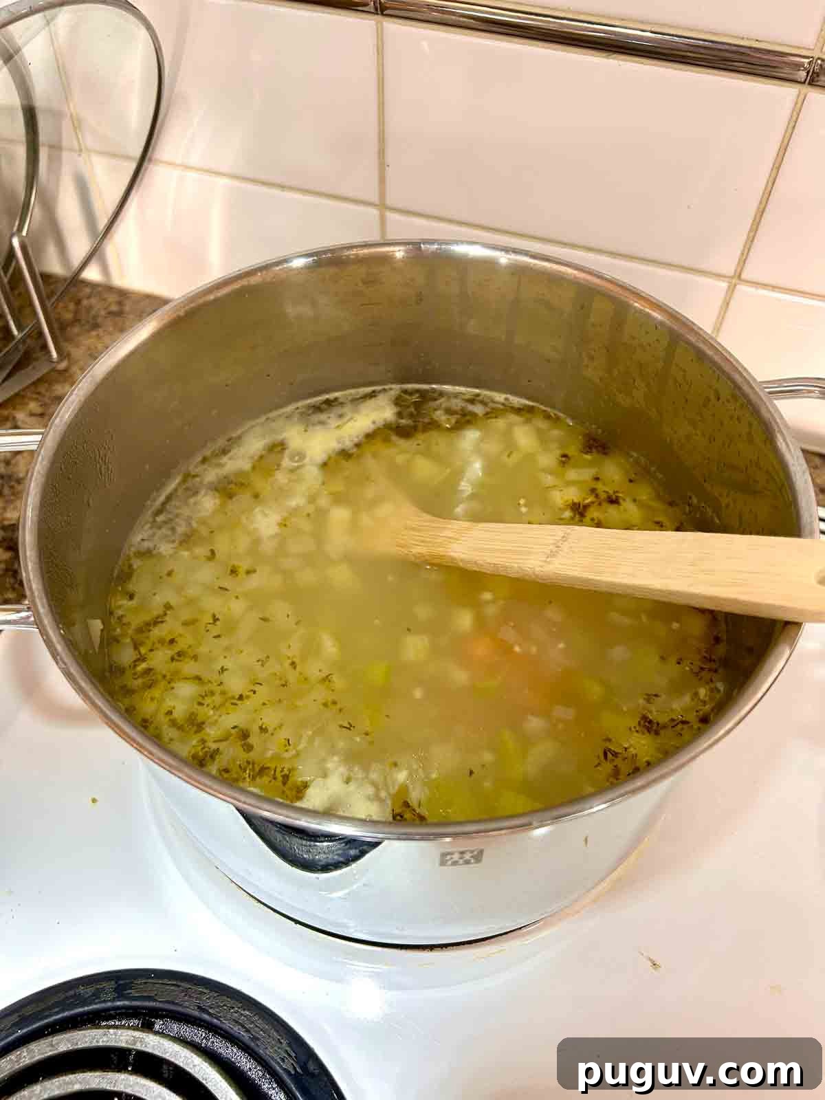 Classic Italian Wedding Soup Recipe — Authentic Homemade Flavor 7 broth and orzo added to pot.
