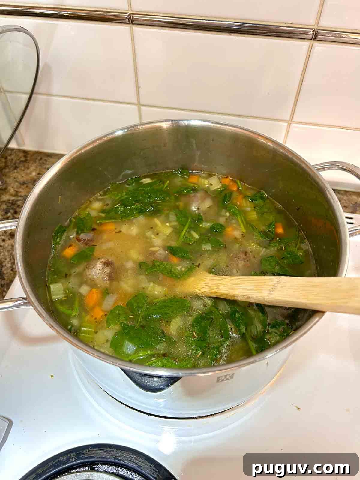 Classic Italian Wedding Soup Recipe — Authentic Homemade Flavor 9 spinach added to pot.
