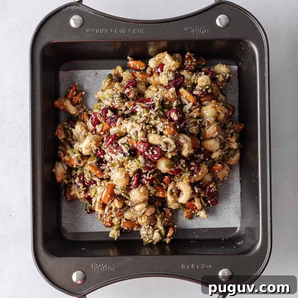 Homemade Fruit and Nut Bars Recipe for Energy and Snacking 6 Seed and nut mixture in a parchment lined tray.