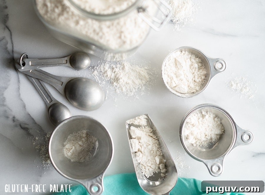 Gluten-free flour in a clear jar with measuring cups and spoons next to it.