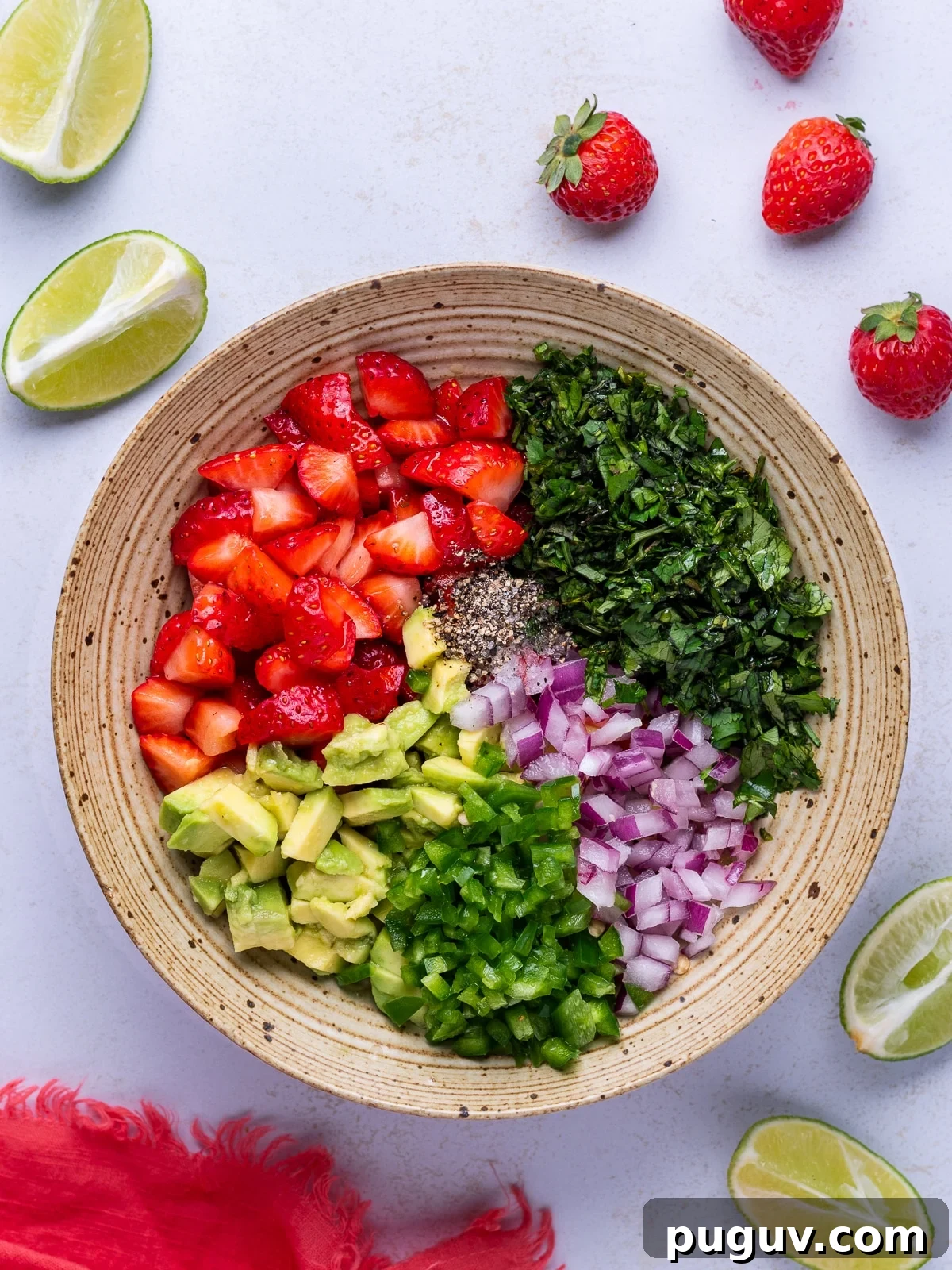 Strawberry Jalapeño Salsa Recipe — Fresh, Spicy Summer Dip 4 ingredients separated in a bowl: cubed strawberries, chopped cilantro, avocado, red onion, jalapeno, salt and pepper
