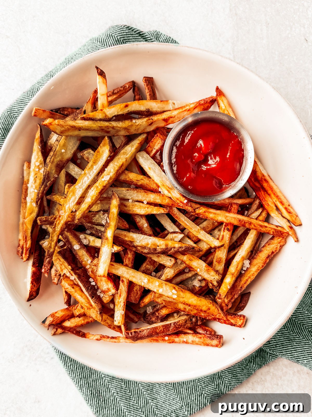 Crispy Air Fryer French Fries with 3 Ingredients 12 Air fryer French fries in a serving bowl with ketchup.