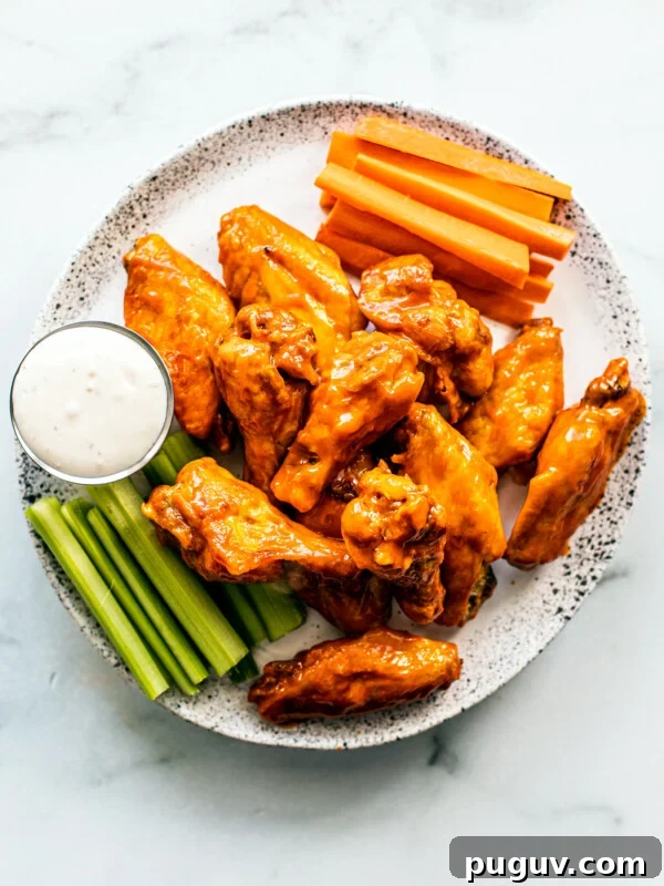 Crispy Air Fryer French Fries with 3 Ingredients 13 Serving plate of saucy buffalo wings with carrot and celery sticks, and blue cheese dip.