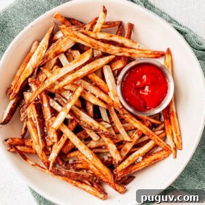 Crispy Air Fryer French Fries with 3 Ingredients 17 Serving bowl of air fryer French fries with ketchup on the side.