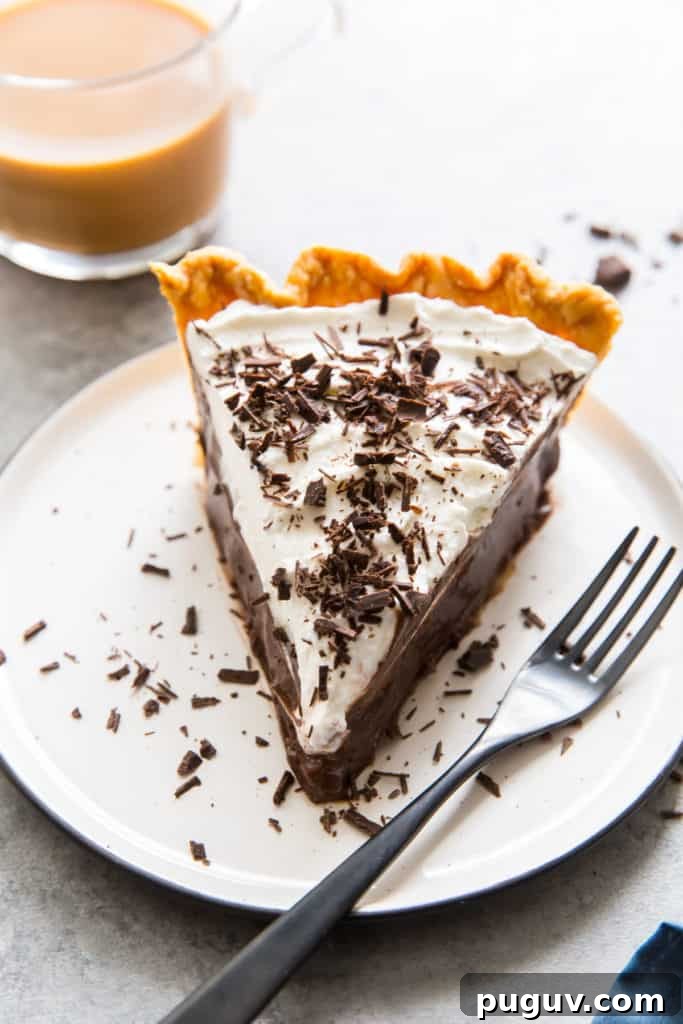 A slice of chocolate pie on a white plate with a fork.