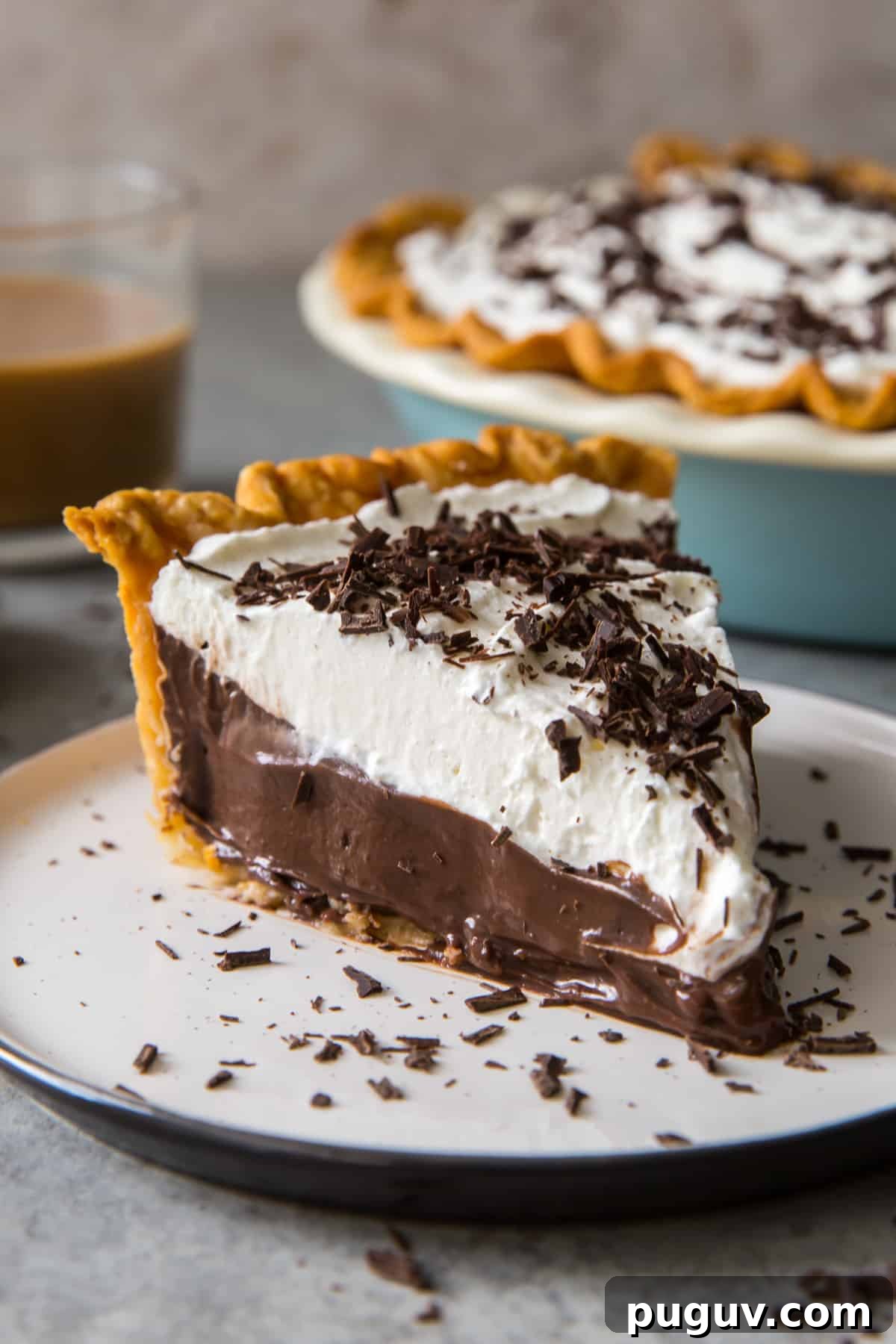 A slice of Chocolate Cream Pie on a white plate.